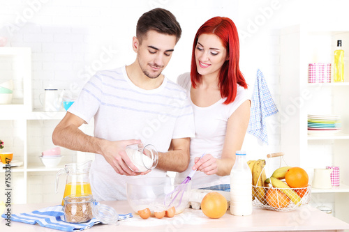 Happy couple preparing dough baking in kitchen