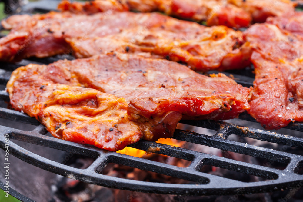 Grilling pork steaks on barbecue grill Grilling pork steaks on barbecue grill