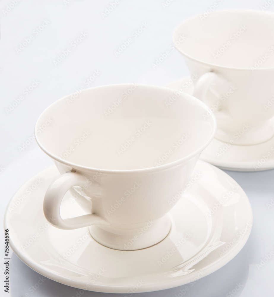 Ceramic saucer and teacup over white background 