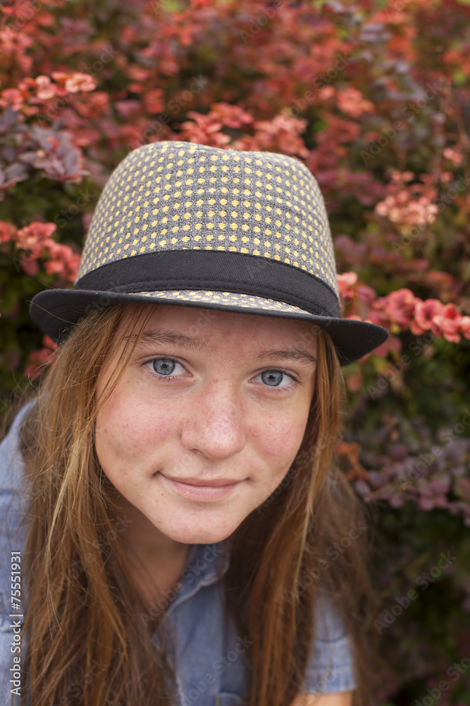Portrait of a young girl in hat in the fall outdoors.