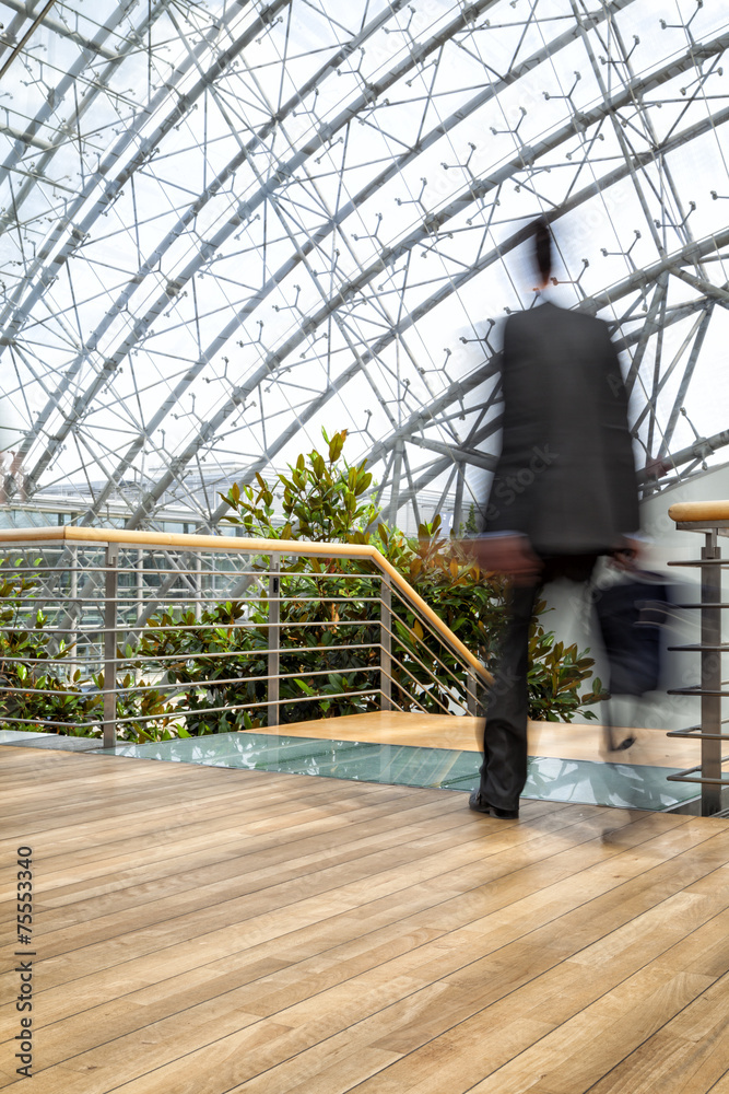 Businessman in hurry, motion blurred people over office building