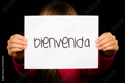 Child holding sign with Spanish word Bienvenida - Welcome