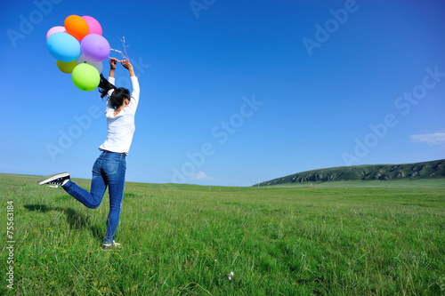 young asian woman run with colored balloons 