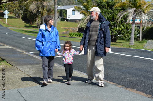 Grandparents walking with their granddaughter