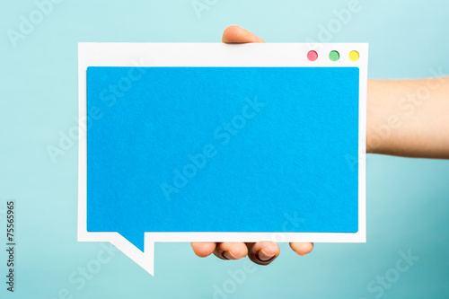 Hand holding blue computer software window, paper speech bubble. photo