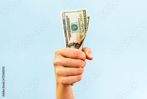 A hand holding a handful of twenty us dollars.