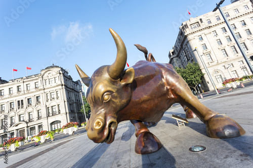 Obraz na plátně Copper Bull statue on the modern city  street of shanghai.