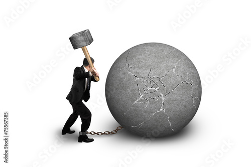 businessman holding hammer hitting cracked concrete ball isolate