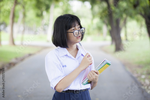 Schoolgirl standing holding a book.