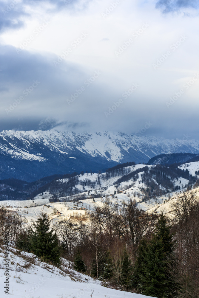 Landscape with snowy mountains under cloudy sky