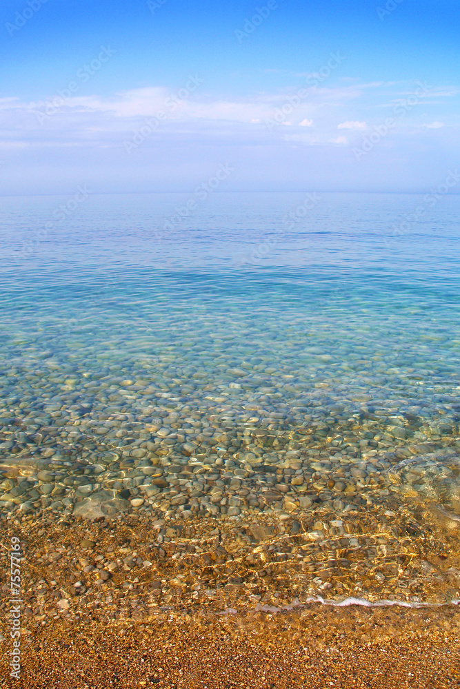 Pebble beach. Calm clear sea, the sky, horizon and stones. Pebble beach. Calm clear sea, the sky, horizon and stones.