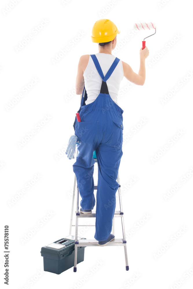 back view of young woman painter in blue coveralls standing on l back view of young woman painter in blue coveralls standing on l