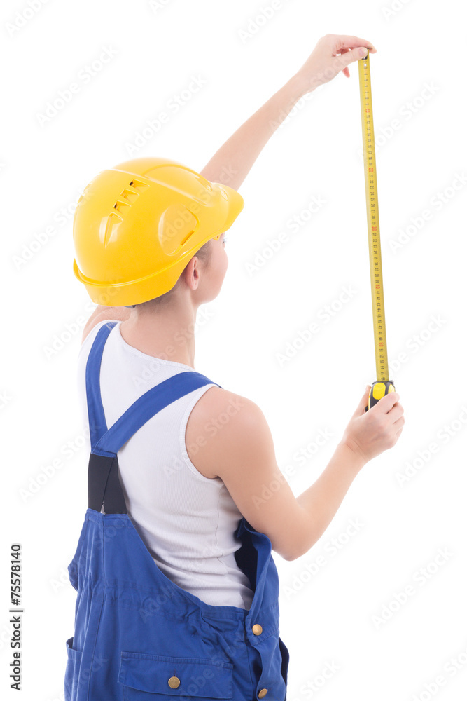 back view of woman builder in blue coveralls measuring something back view of woman builder in blue coveralls measuring something