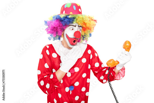 Young surprised clown holding a telephone speaker © Ljupco Smokovski