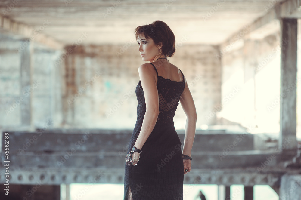 Beautiful woman in black dress in abandon building