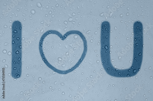 Phrase "I love you" on a foggy blue window.