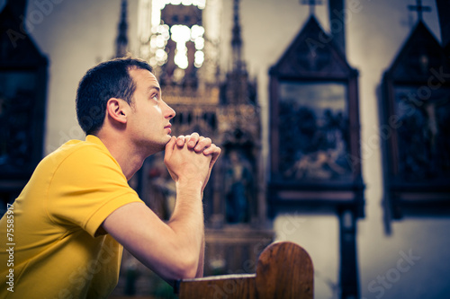 Photography Handsome young man praying in a church