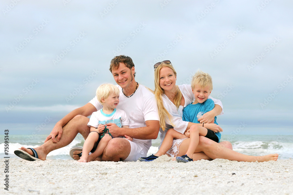 Portrait Of Happy Family of Four People Relaxing on the Beach Portrait Of Happy Family of Four People Relaxing on the Beach