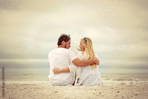 Happy Couple Sitting on Beach by Ocean in Vintage Color 