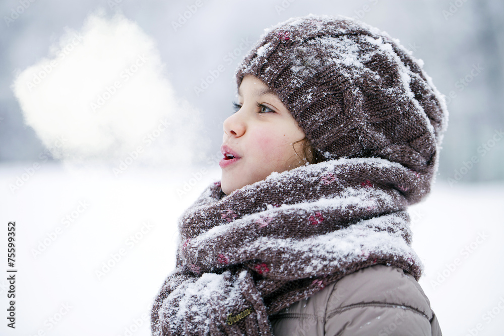 Fototapeta premium Happy little girl on the background of a winter park