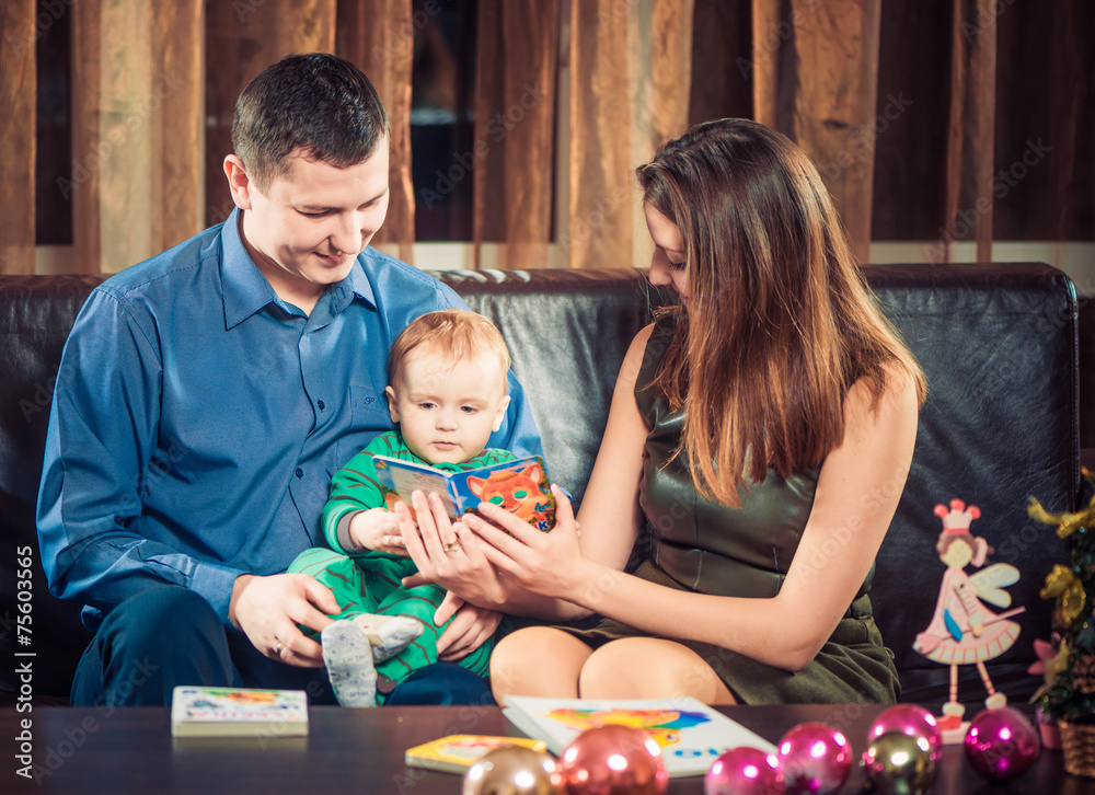 Naklejka premium parents showing book to little son