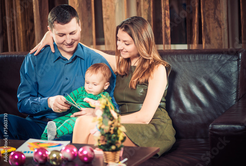 happy parents reading book to little son