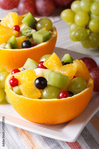 oranges filled with green and red grapes, berries, kiwi