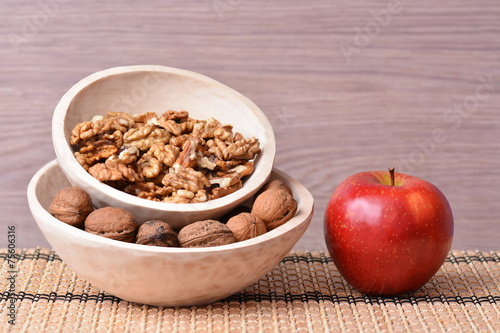 Wooden dishes with fruits, apple and nuts on bowl table photo