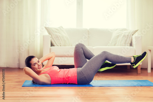 smiling girl doing exercise on floor at home