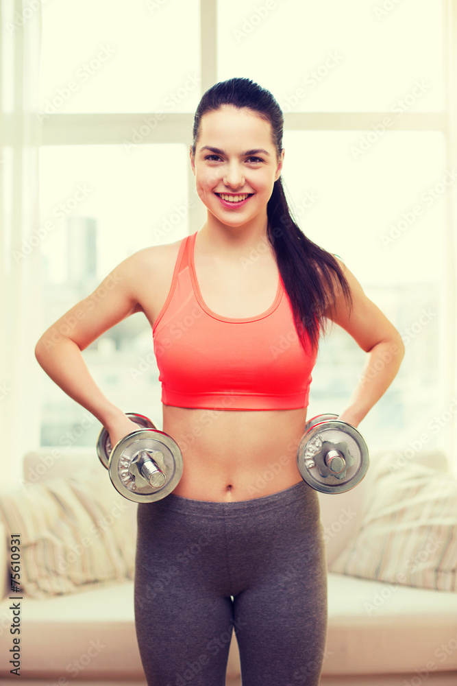 smiling girl exercising with dumbbells smiling girl exercising with dumbbells