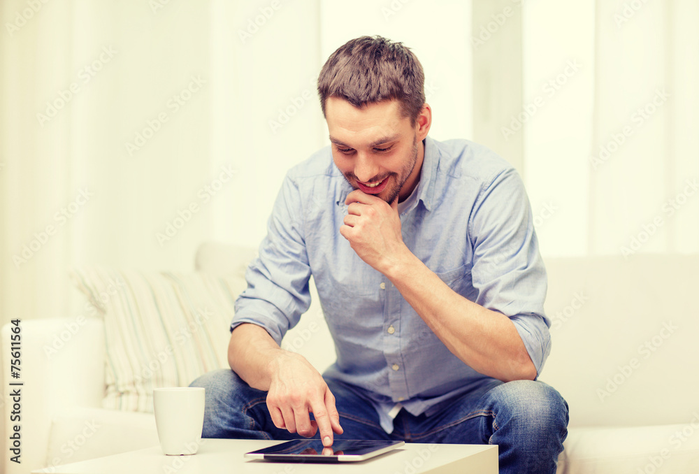 smiling man working with tablet pc at home