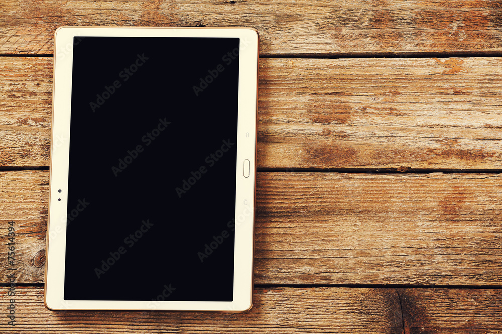 Tablet computer on a wooden background Tablet computer on a wooden background