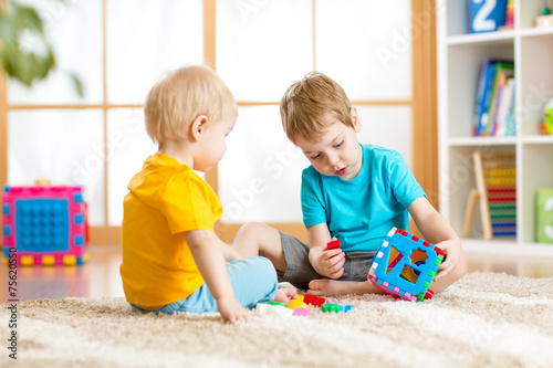 two little boys play together with educational toys