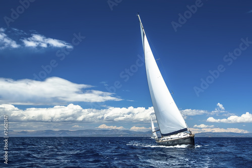 Ship yachts with white sails in the open Sea. Luxury boats.