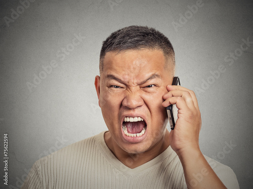 Angry middle aged man employee shouting while on phone