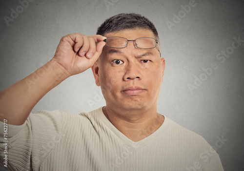 middle aged man with glasses skeptically looking at you photo