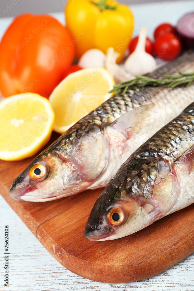 Fresh raw fish and food ingredients on table Fresh raw fish and food ingredients on table