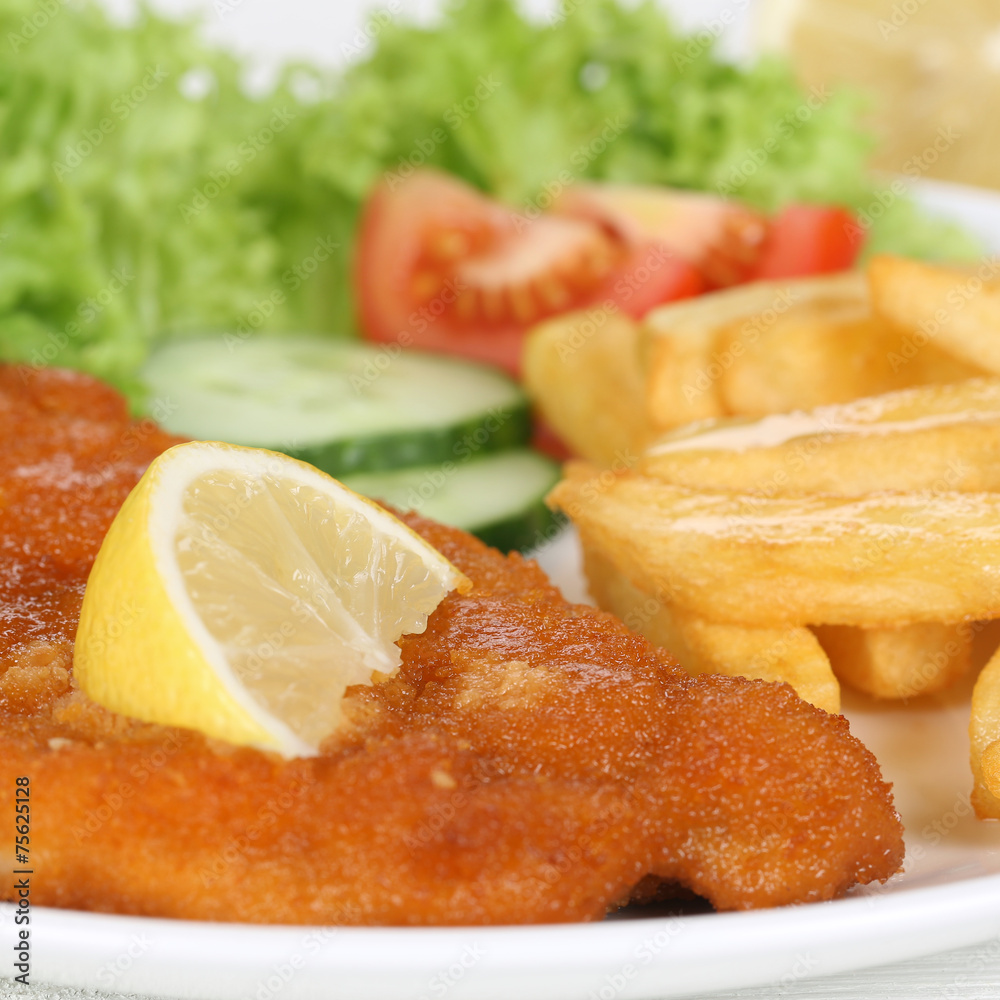 Paniertes Wiener Schnitzel Gericht mit Pommes auf Teller Paniertes Wiener Schnitzel Gericht mit Pommes auf Teller