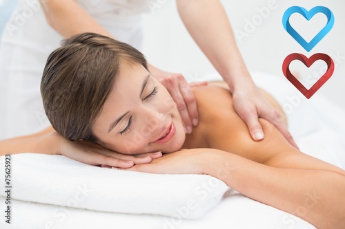Attractive young woman receiving shoulder massage at spa center