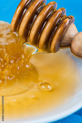 Close view on honey with comp and wooden dipper