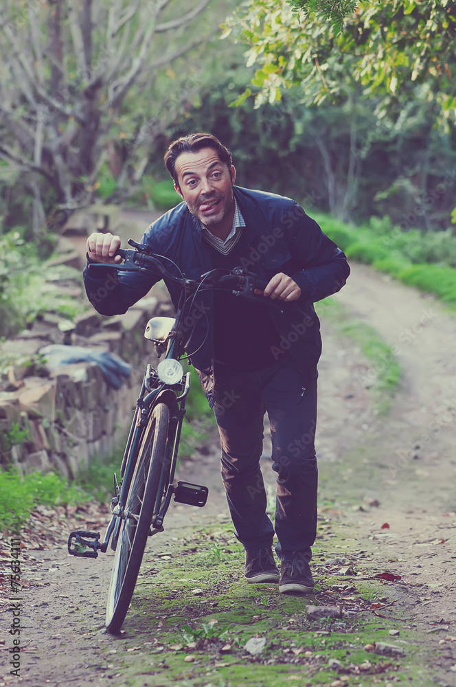 Fototapeta premium Handsome happy biker in the park, toned images