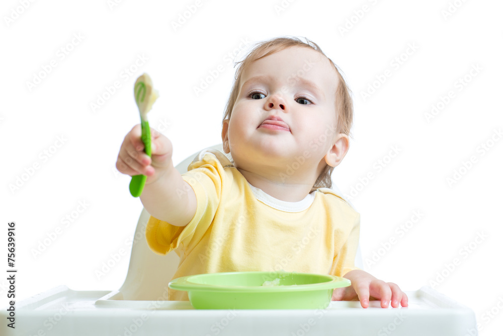 baby child sitting in chair and outstretching a spoon baby child sitting in chair and outstretching a spoon