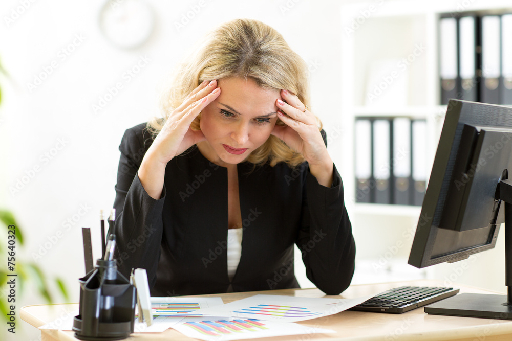 thoughtful business woman looking at business papers in office thoughtful business woman looking at business papers in office