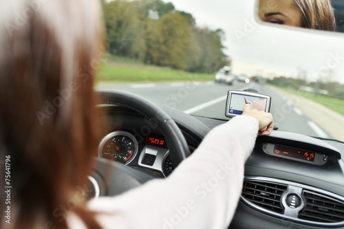 Woman using GPS while driving car