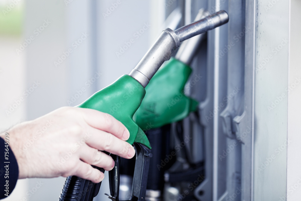 Pumping gas at gas pump. Closeup of man pumping gasoline fuel in Pumping gas at gas pump. Closeup of man pumping gasoline fuel in