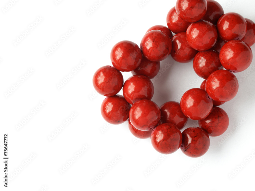 Glossy red coral beads knot on white background