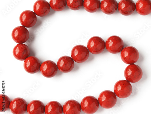 Glossy red coral beads on white background