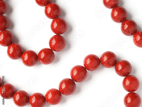 Glossy red coral beads on white background