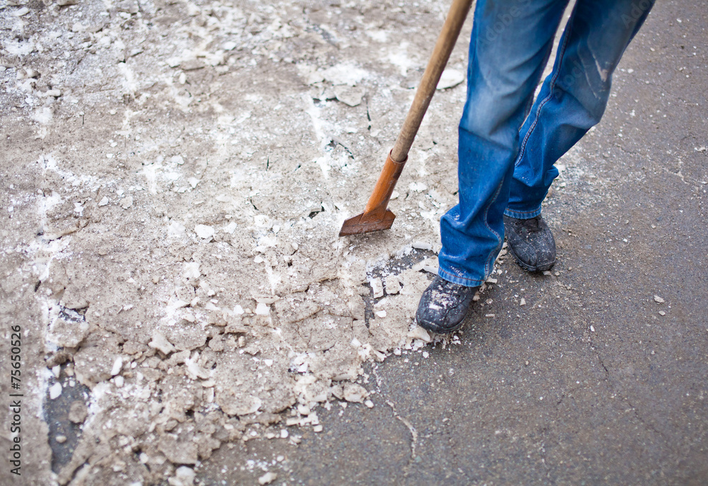 Man with grinder stands on sidewalk near crushed ice after work Man with grinder stands on sidewalk near crushed ice after work