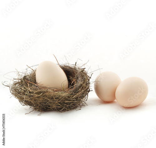 One egg inside the nest and two eggs outside